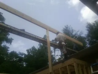 Carpenter setting a ridge beam over a new addition frame — Ice Dam Removal by Roofing Brothers in Rayne